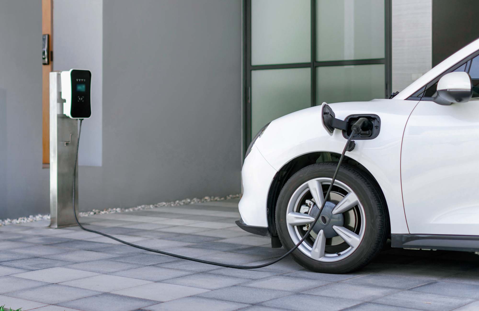 Progressive concept of EV car and home charging station in residential area. Progressive concept of EV car and home charging station powered by sustainable and clean energy with zero CO2 emission for green environmental. Charging point at residential area for electric vehicle.