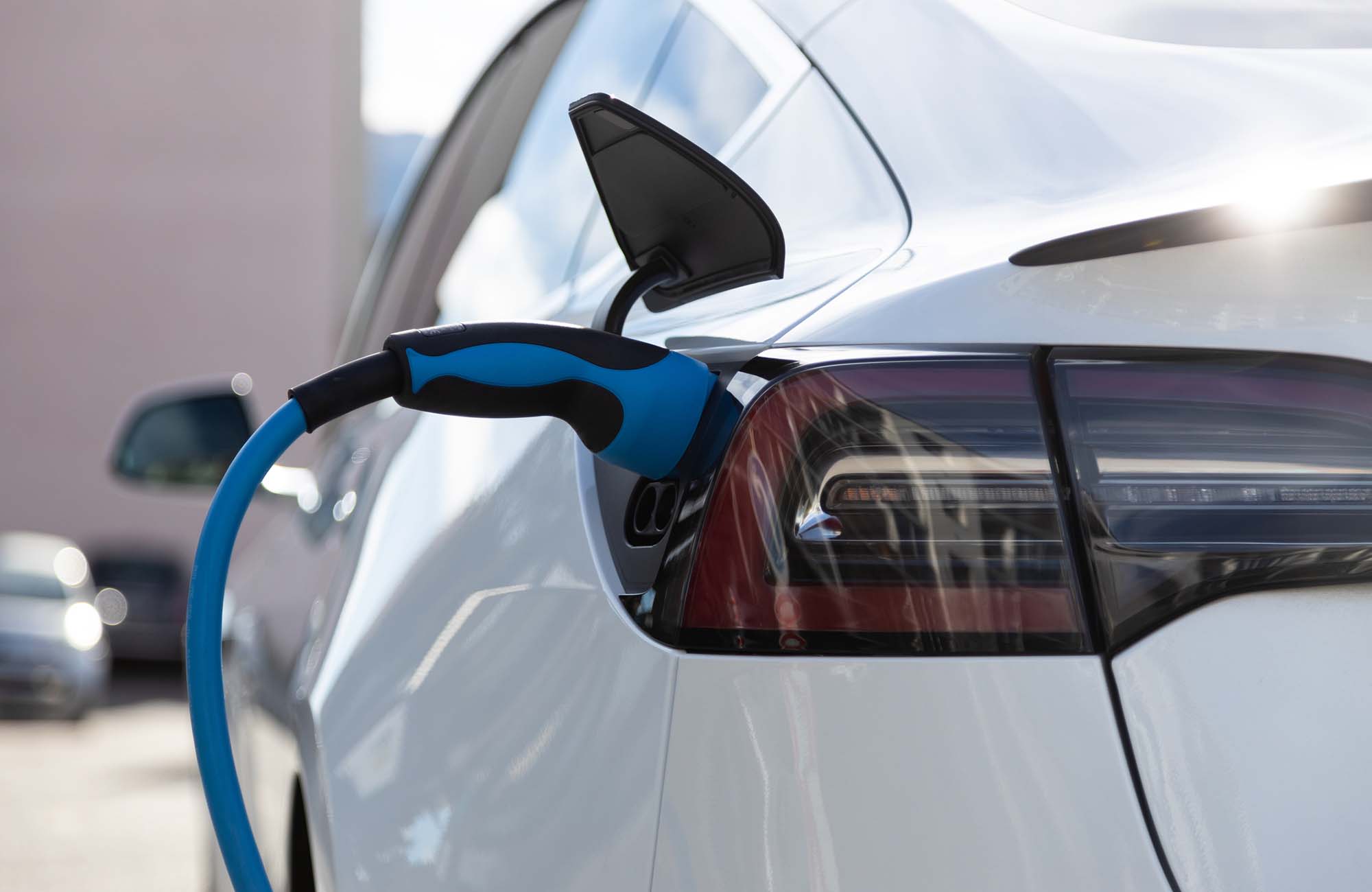 EV electric car pluged charging at a recharge station in the city
